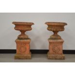 A pair of classical style garden urns on square bases, 73 cm tall. Some wear and weathering. AF (2)