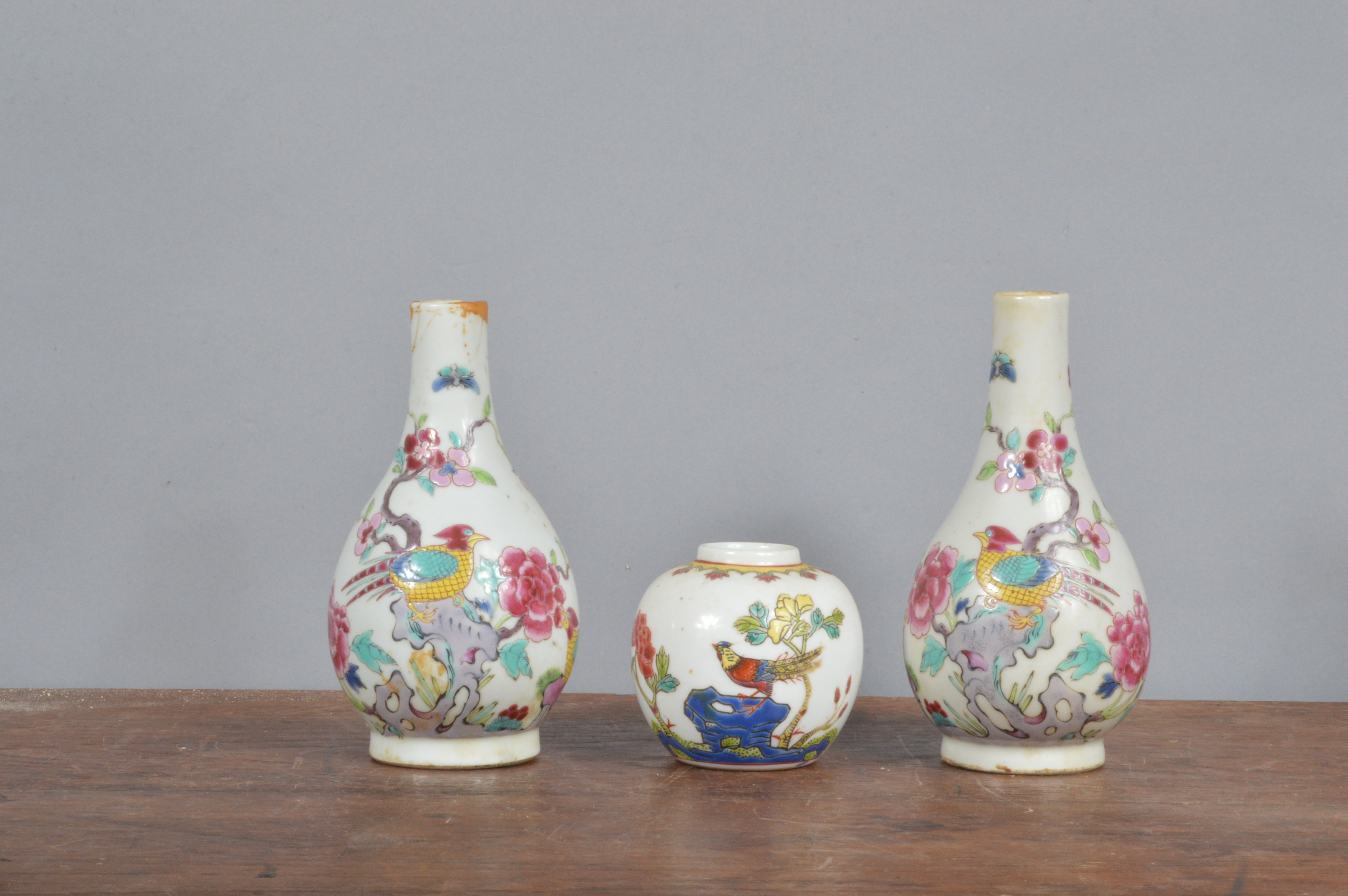 Two Chinese 19th century bottle vases, each decorated with poly chrome designs of birds with peony