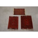 Three small Persian matts, all with red grounds and differing designs, the largest 70cm x 52cm (3)