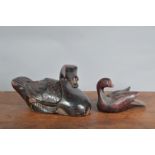 Two far eastern style decoy ducks, the largest example ebonised wood with a worn red painted finish,