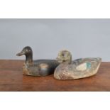 Two antique wooden decoy ducks, both hand painted, the larger with glass eyes, and stamped to the