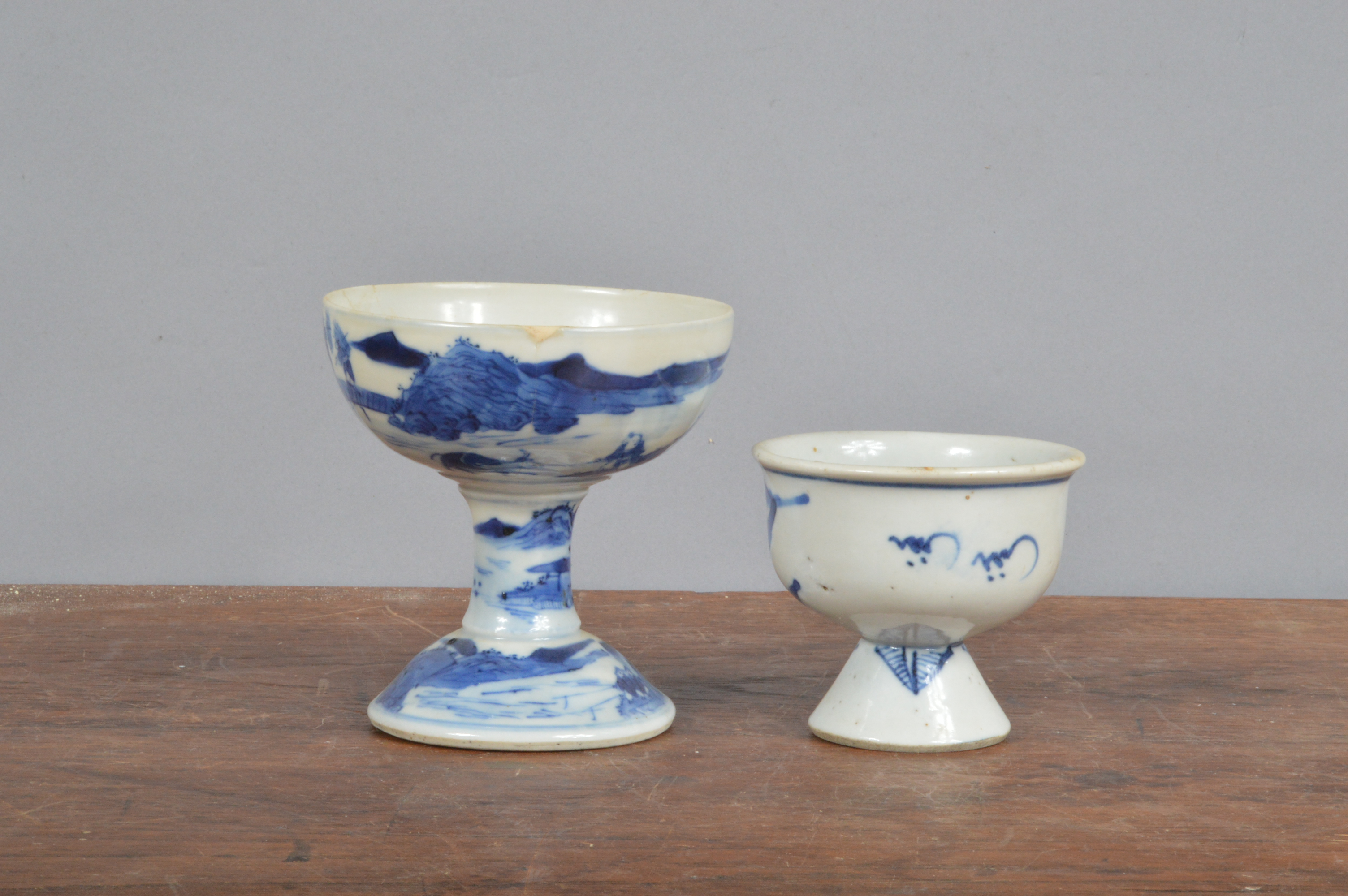 Two 19th century blue and white Chinese porcelain footed cups, each decorated with a landscape