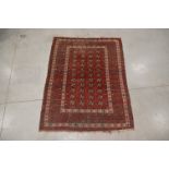 A tekke geometric wool on wool rug, red ground, some wear and fading, 190cm x 142cm