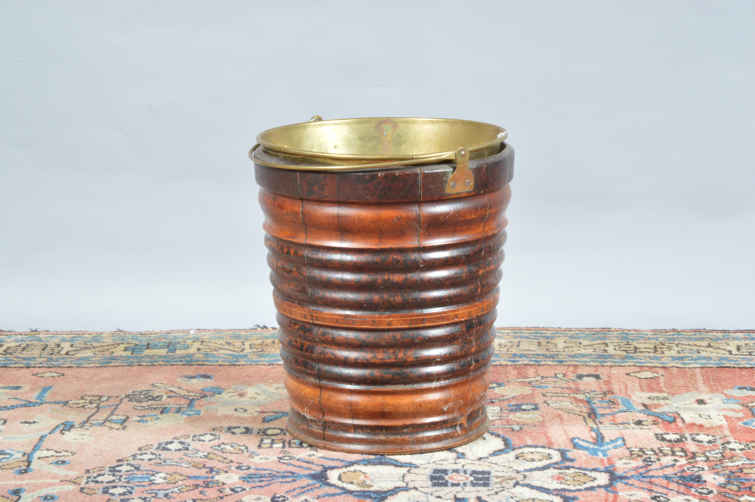 A turn of the century peat bucket, ribbed wooden design with brass carrying handle and liner, 33cm