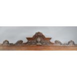 A 19th century pediment, oak with swag decoration and a central carved knights helmet flanked by