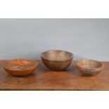 Three 19th century elm primitive treen bowls, of slightly differing sizes and designs, some minor