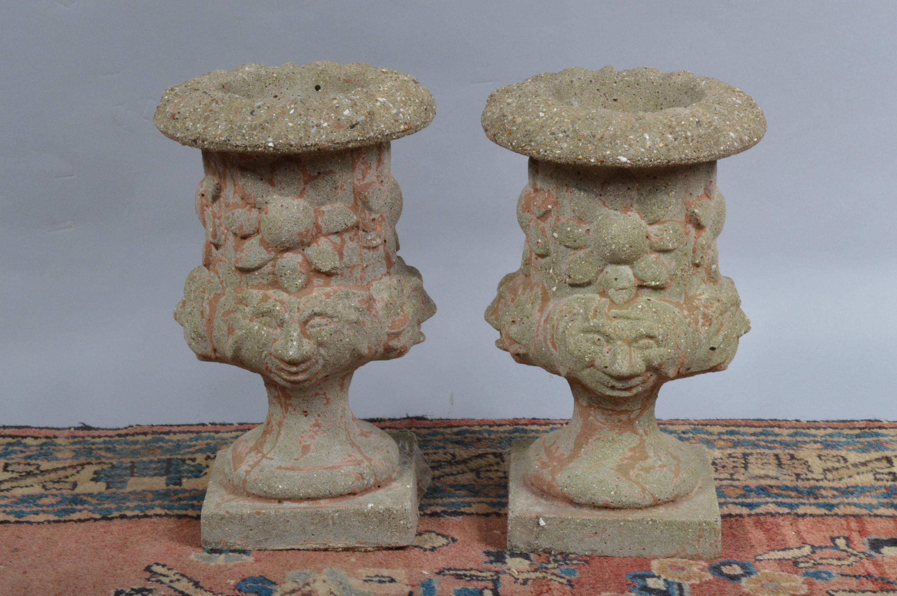 A pair of short concrete planters, in the classical style, both approx. 34 cm tall (2)