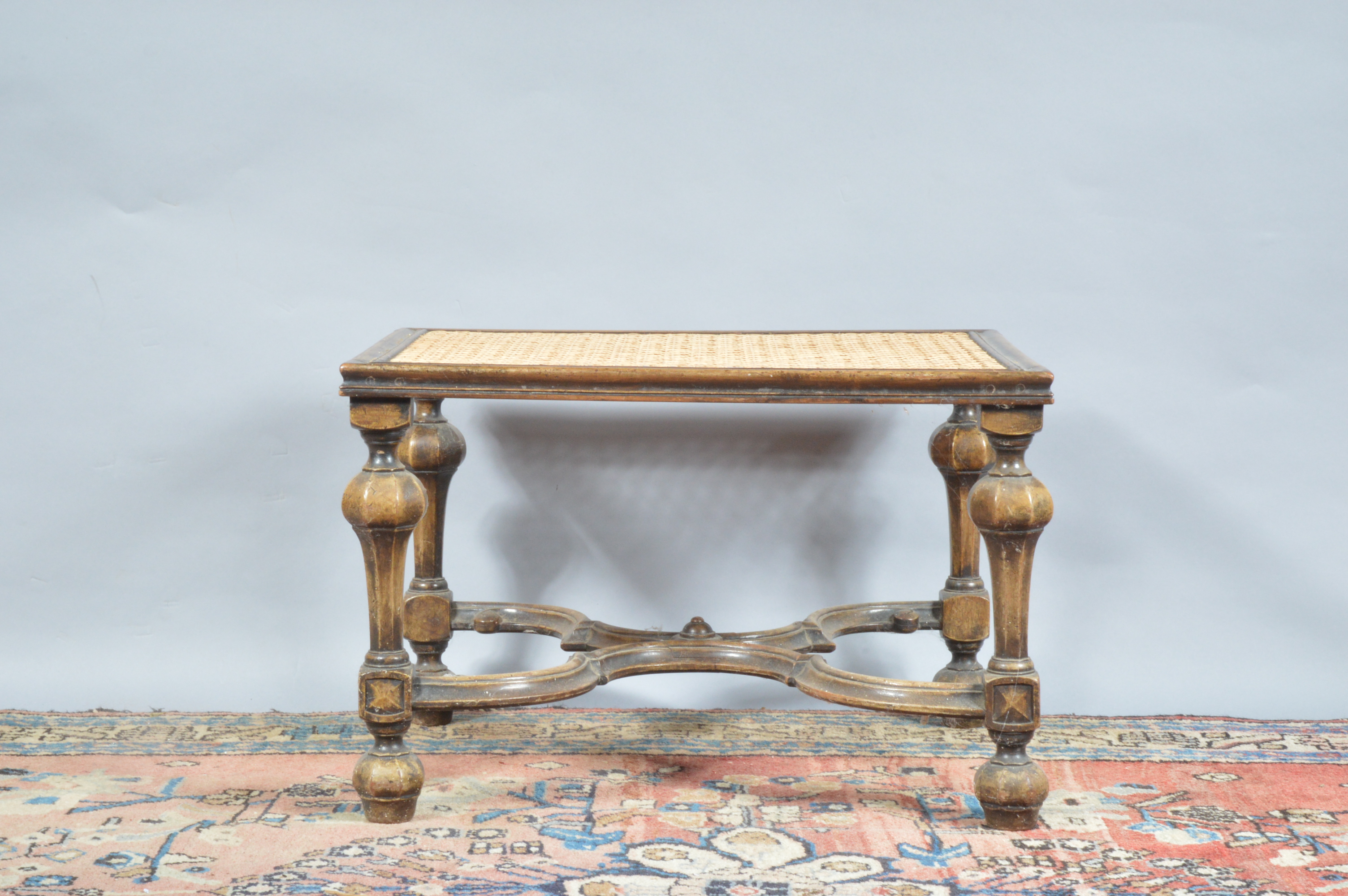 A 19th century continental possibly Italian footstool, newly caned top, raised on four turned