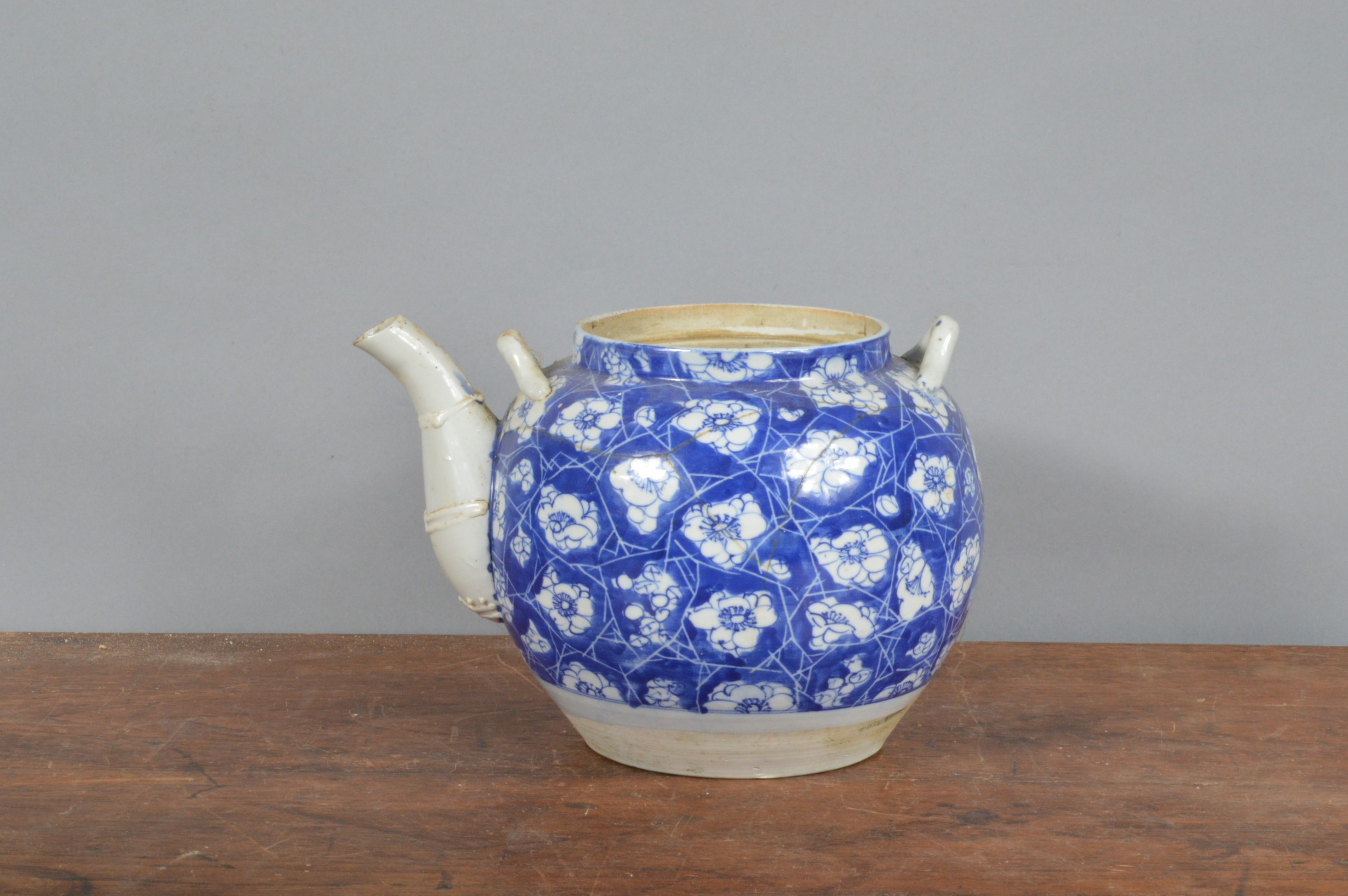 A 19th century Chinese hand-painted blue and white teapot, decorated with cracked ice and prunus.