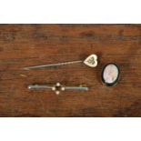 An Art Deco and seed pearl bar brooch, marked 750, a heart shaped stick pin and an oval shell