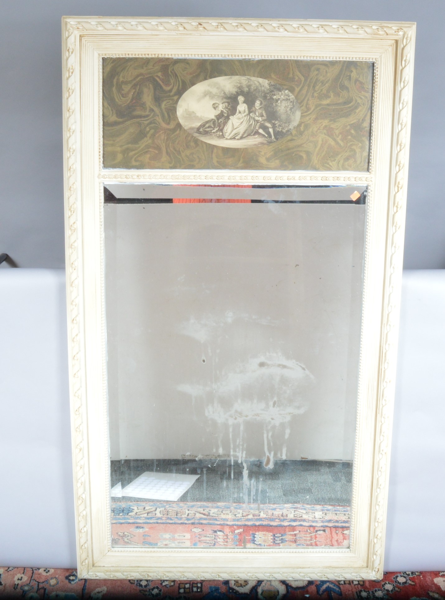 A large carved mid 20th century mirror, white painted carved wooden frame, the top panel with an