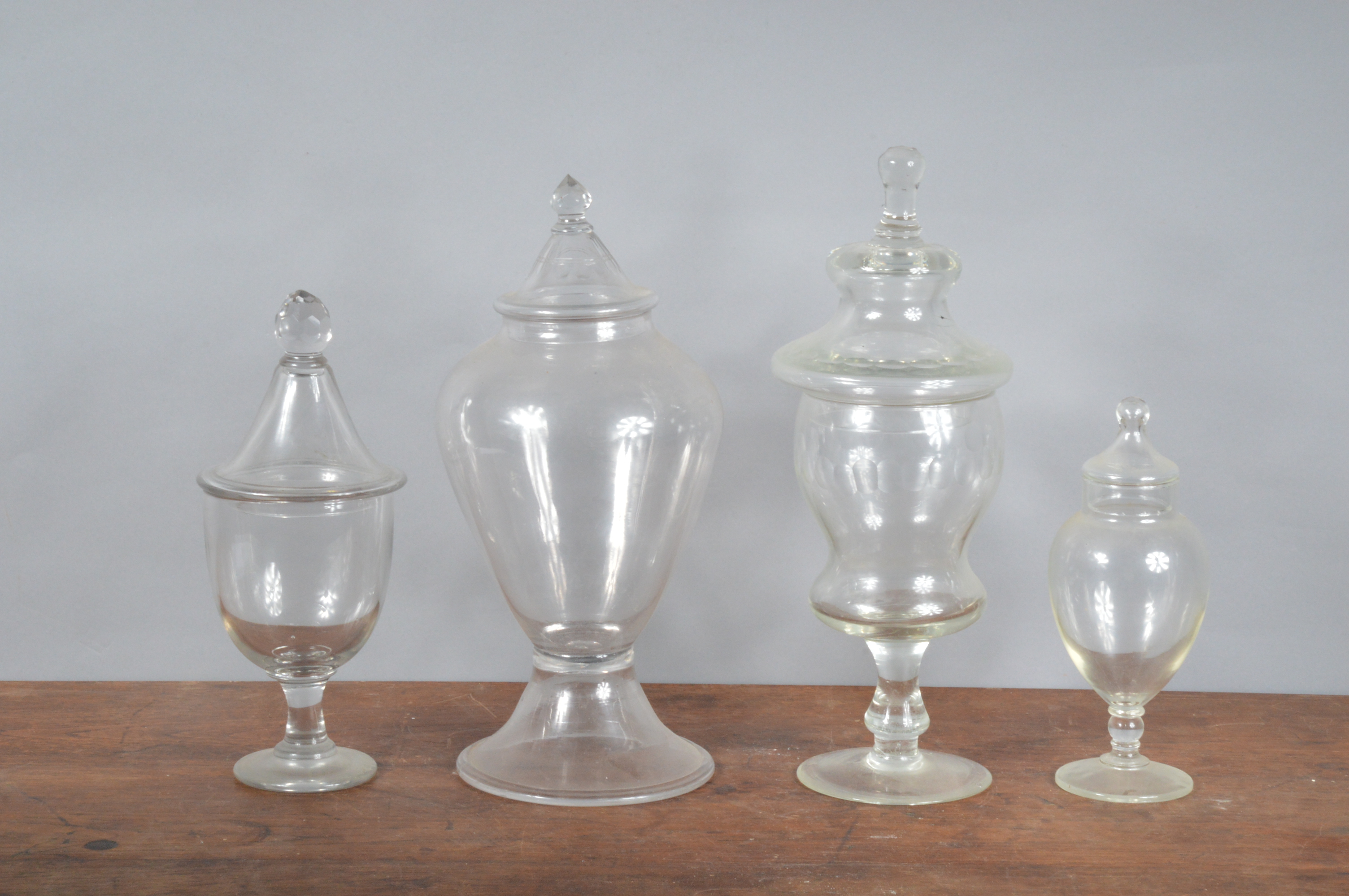 Four 19th century and later glass jars with covers, of differing designs and styles, the tallest