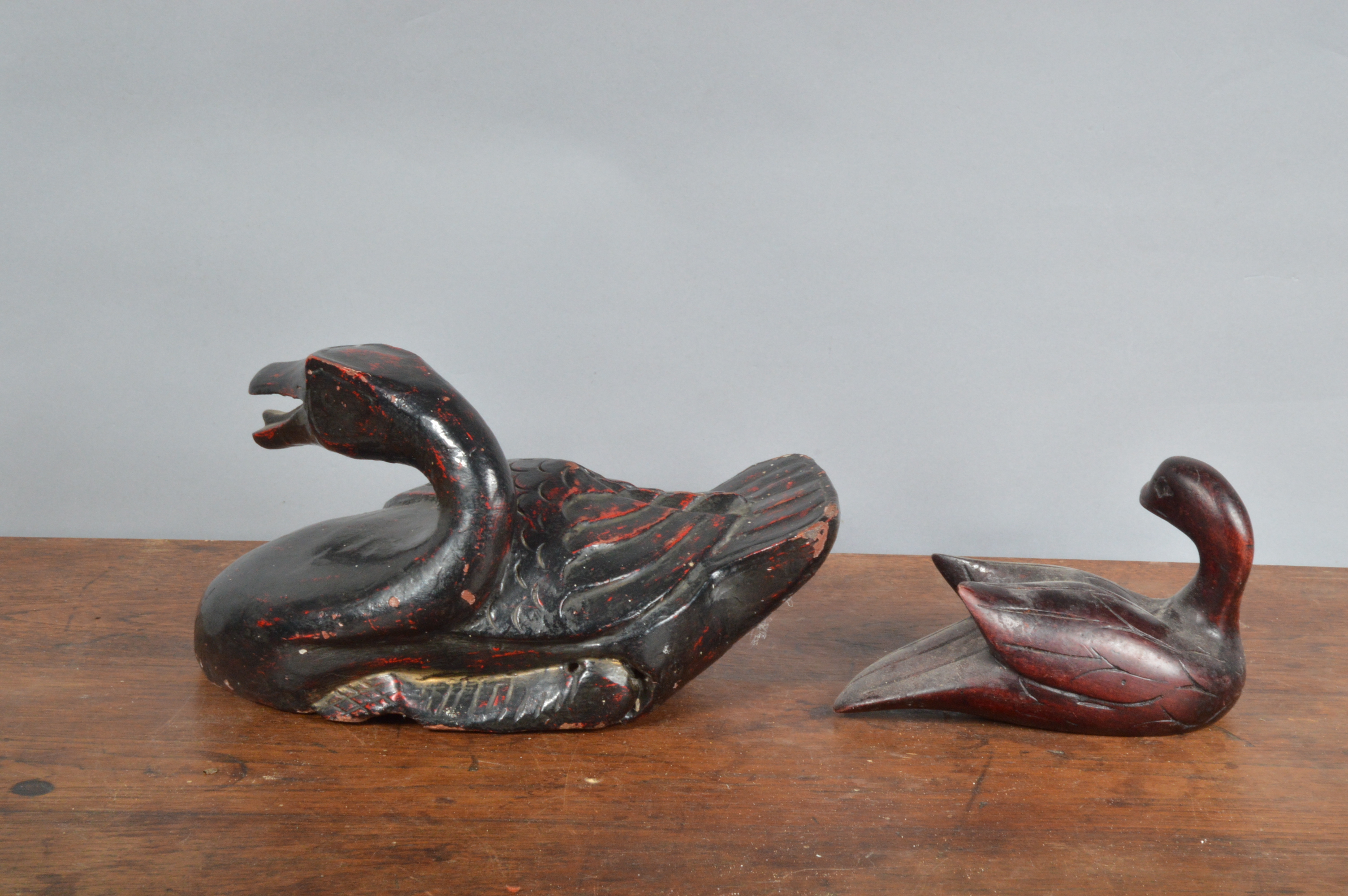Two far eastern style decoy ducks, the largest example ebonised wood with a worn red painted finish, - Image 2 of 2
