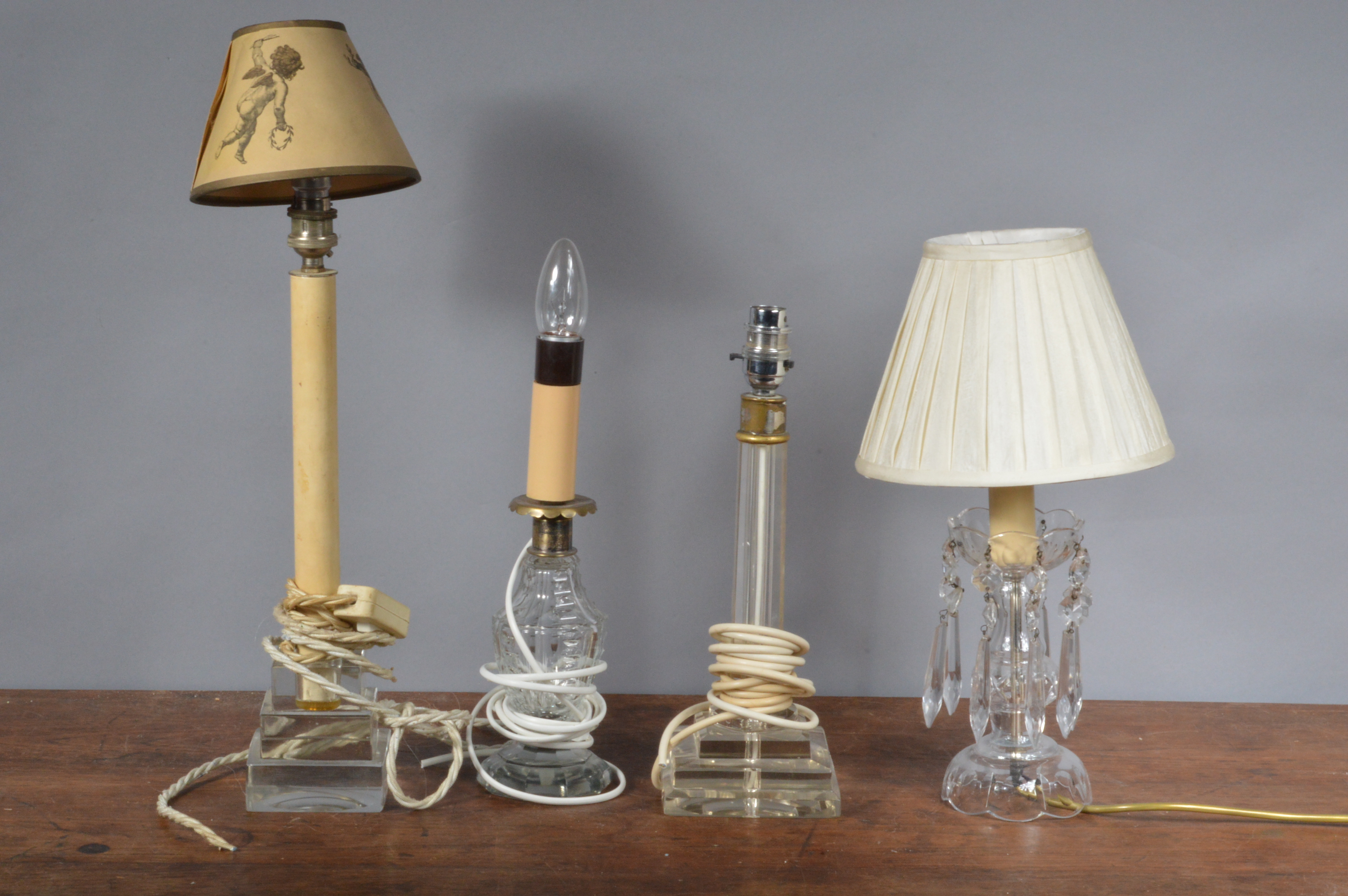 Four glass 20th century table lights, one a lustre example, two neoclassical form, and one other.