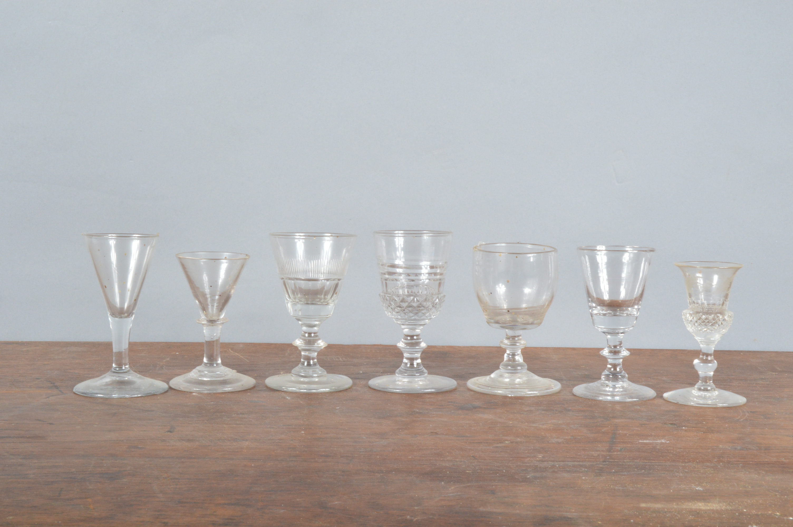 A collection of 19th century and later sherry or port glasses, including one with thistle cut