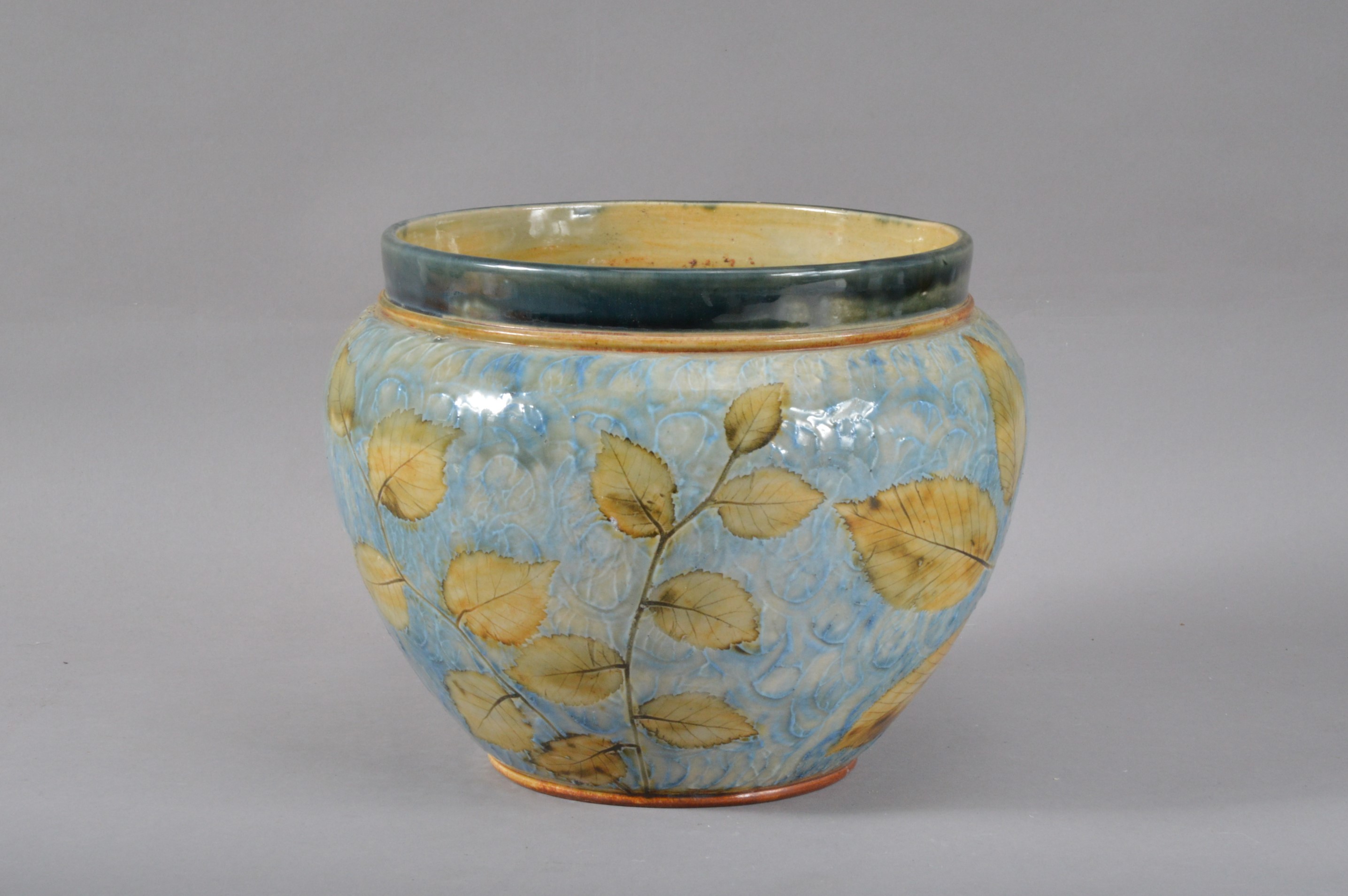 A Royal Doulton stoneware planter/ jardiniere, with a floral design on a light blue ground, dark