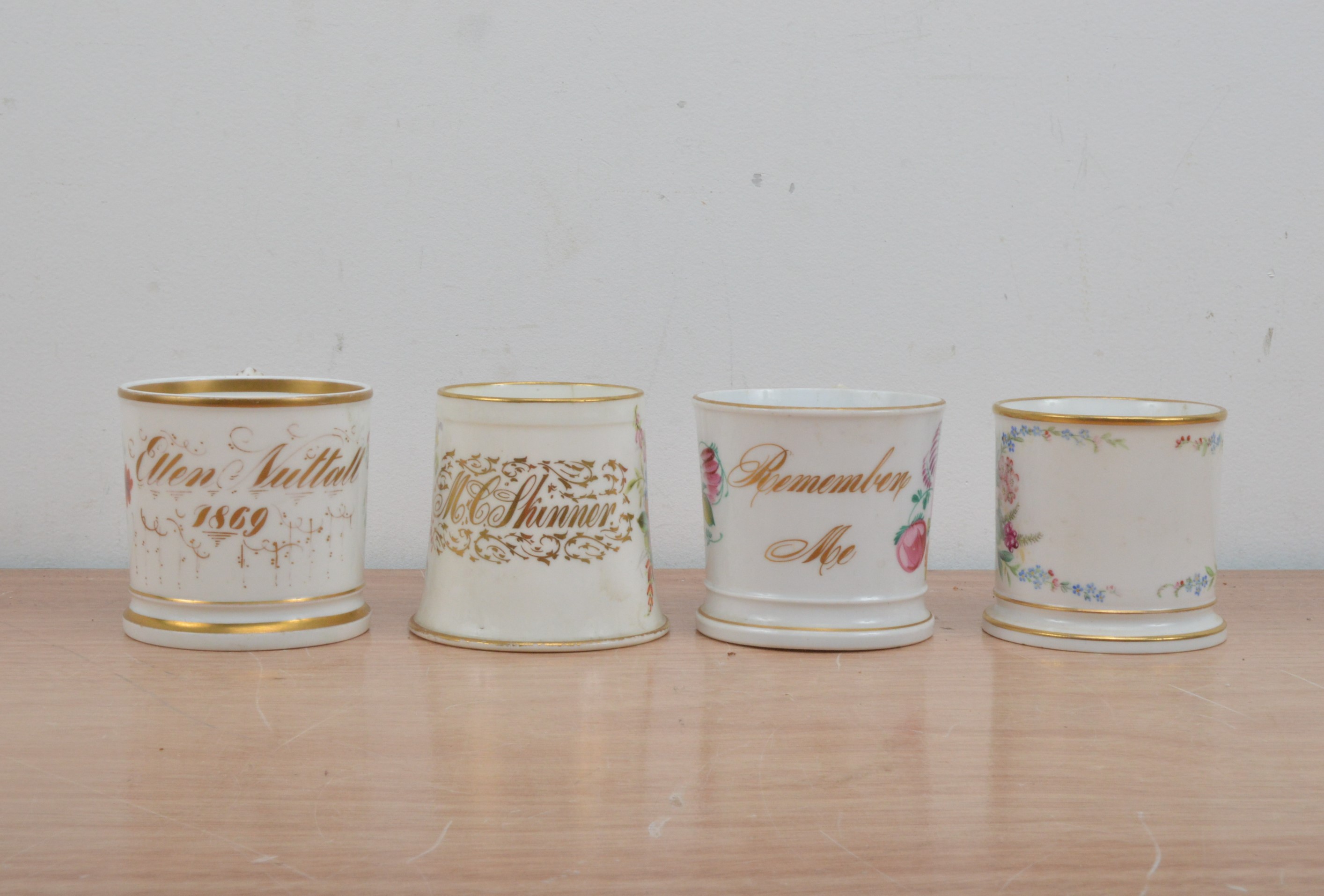 Four Victorian English porcelain mugs, all with painted floral decoration and heightened gilt