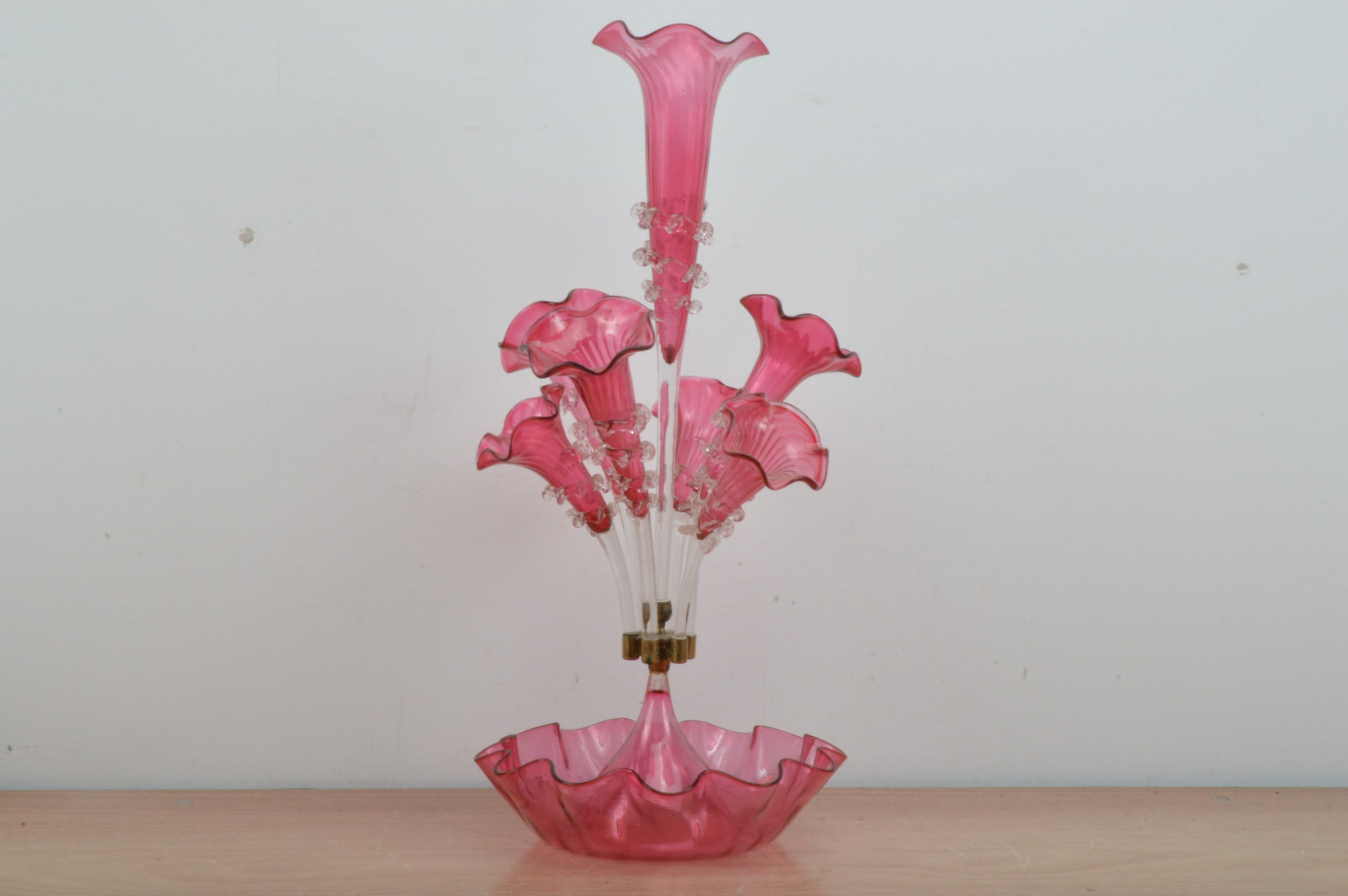 A Victorian cranberry glass epergne, shaped base, with a large central trumpet with trailing