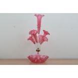 A Victorian cranberry glass epergne, shaped base, with a large central trumpet with trailing
