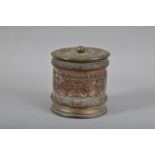A 19th century brass tobacco jar, foliate scrollwork decoration, the cover with a copper finial,
