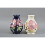 Two Moorcroft pottery vases, both with floral design, one with a cream ground the other a blue