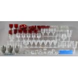 A large collection of glassware, including cranberry glasses and bowls, the largest bowl 20cm