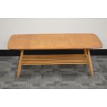 A 1960's/1970's elm Ercol coffee table, rounded rectangular top, on four supports with an under-