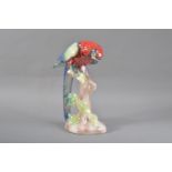 A large Jema Holland ceramic lustre parrot figurine, on a perch, impressed marks to the underside