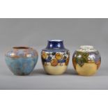 Three Royal Doulton stoneware vases, all of baluster squat form, the tallest with a floral design,