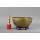 A 20th century Far Eastern brass and inlaid singing bowl, the exterior with a script, the well