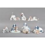 A collection of Lladro and Nao porcelain puppy figurines, comprising three Nao playful puppy figural