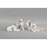 Four Lladro porcelain dog figurines, all of differing poses, one a basset hound with a paper in