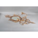 A turn of the century tole gilt mirrored wall sconce, foliate scroll decoration, oval shaped