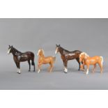 Four 20th century ceramic Beswick horses, two larger dark brown examples, the largest 21cm H x