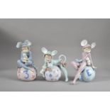 Three Lladro porcelain figurines, all wearing mouse outfits, sitting on balls, the tallest 19cm