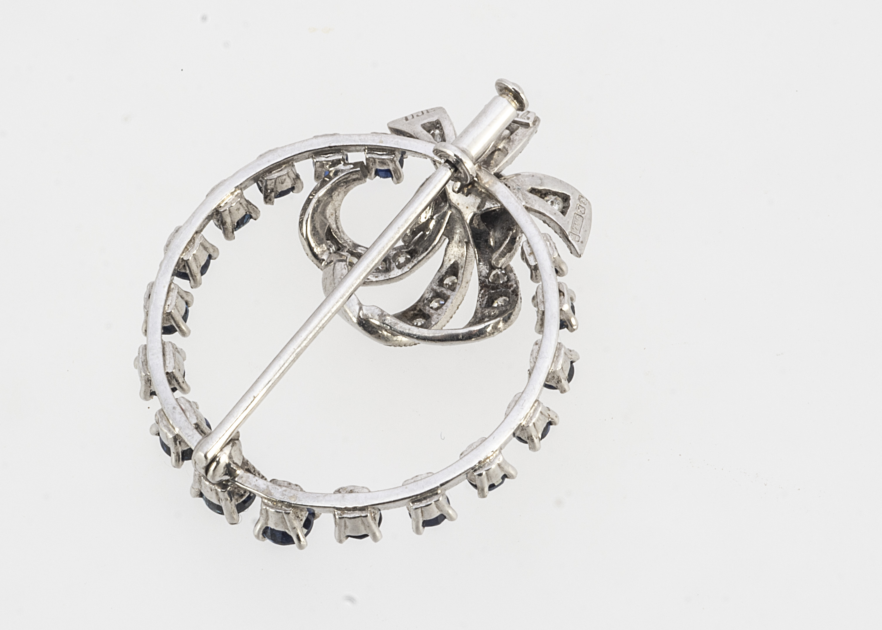 A continental white gold sapphire and diamond bow brooch, of open work circular design, round cuts - Image 2 of 2