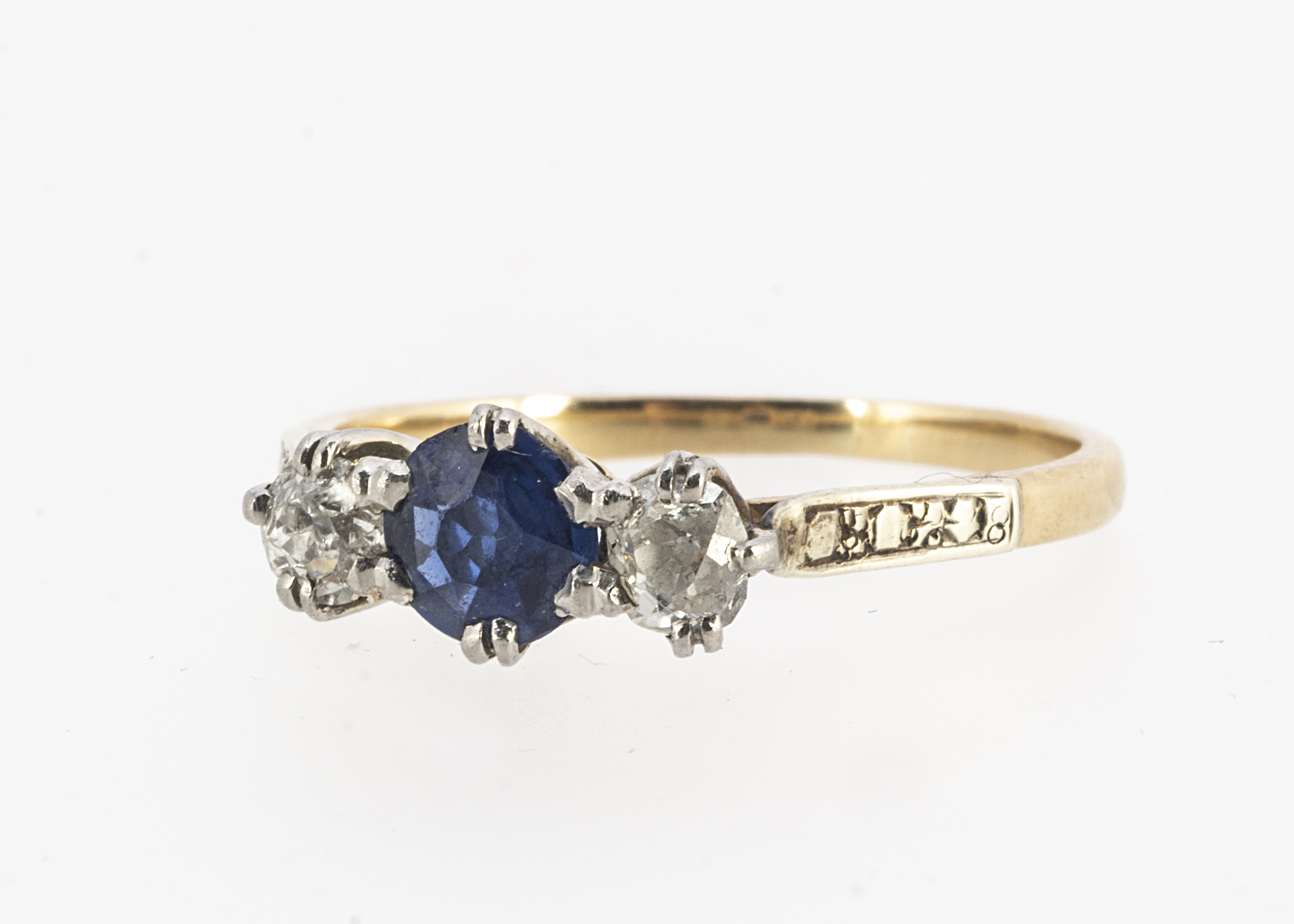 An 18ct gold and platinum three stone diamond and sapphire ring, the central circular claw set