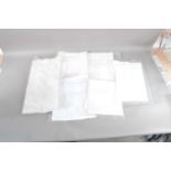 A collection of white vintage tablecloths,