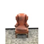 An early 20th century leather wingback armchair,