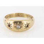 An 18ct gold three stone gypsy set diamond dress ring,