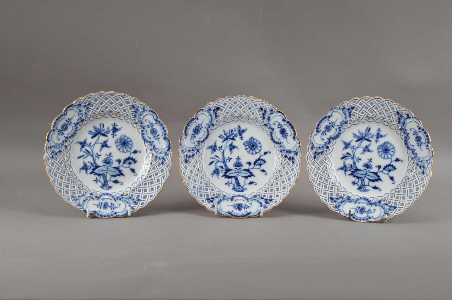 Three turn of the century Meissen porcelain reticulated plates, blue and white foliate design with g