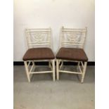 A pair of white painted 'bamboo' style kitchen chairs,