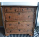 A large 17th century and later oak chest if drawers, two short drawers over three long, with later t