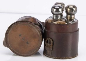 An early 20th century leather cased set of travel bottles,