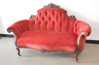 A Victorian carved walnut and upholstered settee,