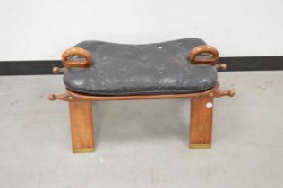 A modern Middle Eastern hardwood and leather camel stool,