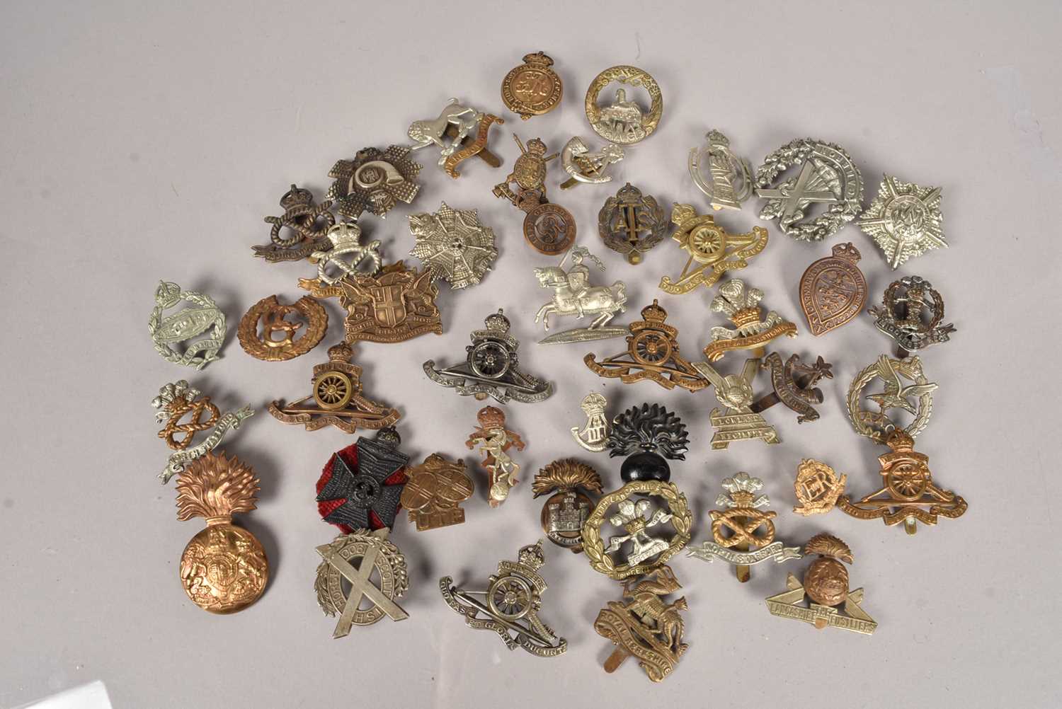 A collection of WWI and later Regimental cap badges,