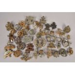 An assortment of WWI and later British Regimental Cap Badges,
