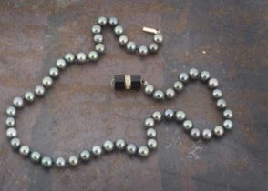 A black cultured pearl uniform knotted strung necklace,