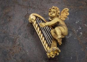 A Continental 18ct gold brooch or pendant depicting Cupid playing harp,